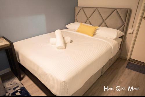 a bed with two white towels on top of it at Hotel COOL MAMA in Brinchang