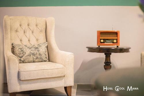 a chair with a pillow and a radio on a table at Hotel COOL MAMA in Brinchang