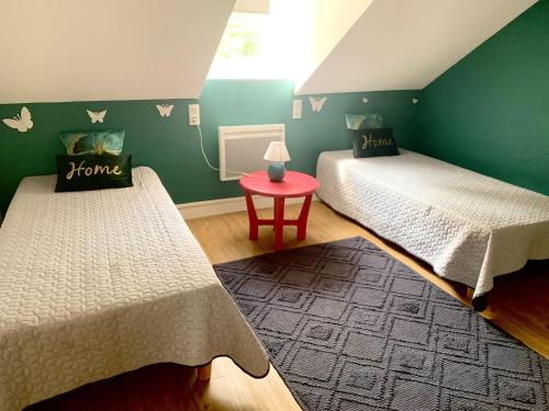 Ce lit se trouve dans un dortoir doté de murs verts et d'une table. dans l'établissement Appartement de 2 chambres avec balcon et wifi a Bagneres de Bigorre, à Bagnères-de-Bigorre