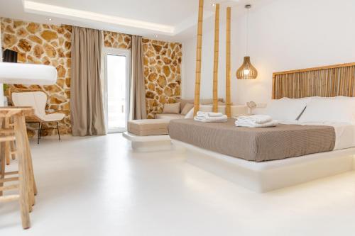 a bedroom with a bed and a living room at Krina Mare Boutique Hotel in Naxos Chora