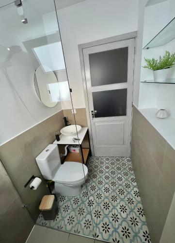 a bathroom with a toilet and a sink and a mirror at Casa Família Açoriana in Vila Franca do Campo