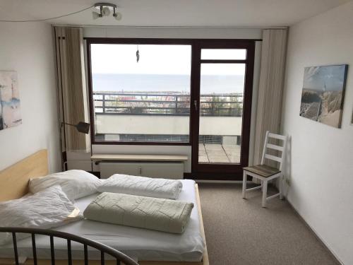 a bedroom with a bed and a large window at Penthouse Kapitänsdeck in Damp