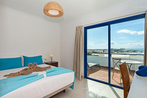 - une chambre avec un lit et un balcon avec vue dans l'établissement 3BR Home - Private Heated Pool - Parking, à Playa Blanca