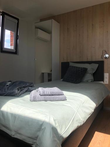 a large white bed with a towel on it at Hotel Fi'Lin in Machelen