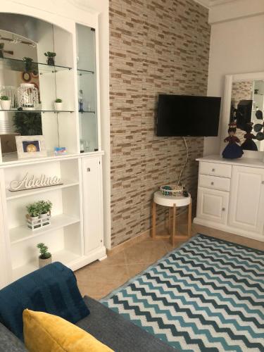 a living room with a tv on a brick wall at Familia Sequeira in Nazaré