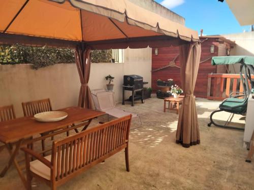 a patio with an umbrella and a table and chairs at Casa Vacanze Marinella in Marinella di Selinunte