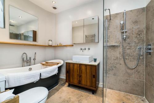 uma casa de banho com um chuveiro, um lavatório e um WC. em Stunning 3BD Flat Shoreditch with Hidden Garden em Londres