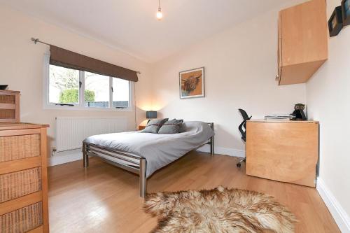 a bedroom with a bed and a window at Gorgeous 3BD Cottage in the Heart of Guildford in Guildford