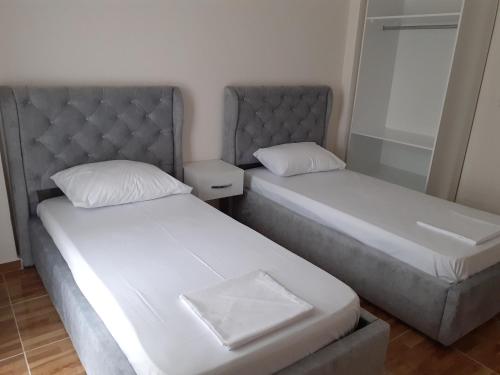 two beds sitting next to each other in a room at Drini Apartments in Përmet