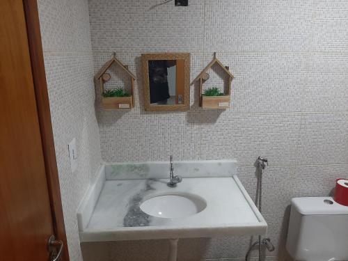 a bathroom with a sink and a mirror and a toilet at Condomínio Beach Place Cumbuco. Ap: 206, Bloco 2 Paradise... in Caucaia
