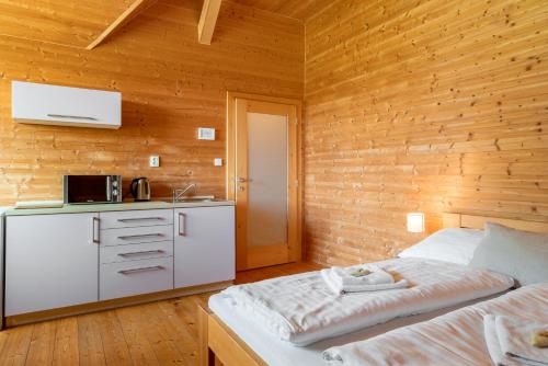 a bedroom with a bed and a kitchen with a microwave at Cedrový penzion in Dobříkov