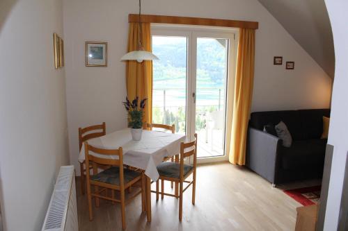 a dining room with a table and chairs and a window at Haus Franz in Millstatt