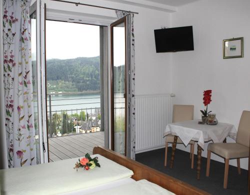 a room with a balcony with a view of the water at Haus Franz in Millstatt