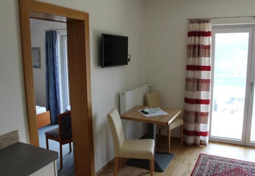 a room with a table and a television on the wall at Haus Franz in Millstatt