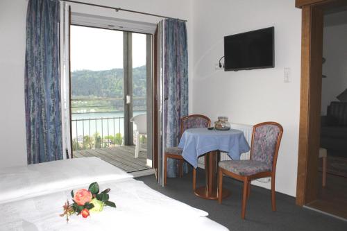 a room with a table and chairs and a balcony at Haus Franz in Millstatt