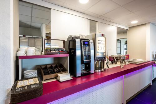 ein Café mit einer Theke mit einer Limo-Maschine in der Unterkunft B&B HOTEL Romilly-sur-Seine in Romilly-sur-Seine