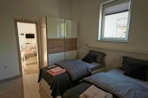 a small bedroom with two beds and a mirror at Apartments Drevi in Ljubljana
