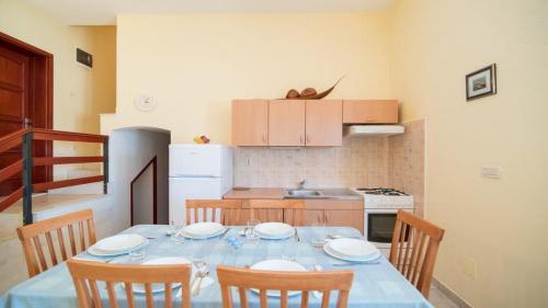 a dining room table with chairs and a blue table cloth at Apartments Ana & Bogdan in Postira