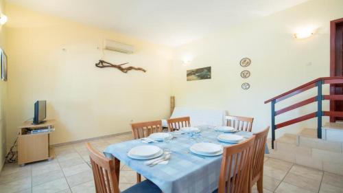 a dining room with a blue table and chairs at Apartments Ana & Bogdan in Postira