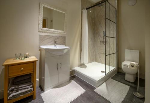 y baño con ducha, lavabo y aseo. en Kirkaig Lodge en Lochinver