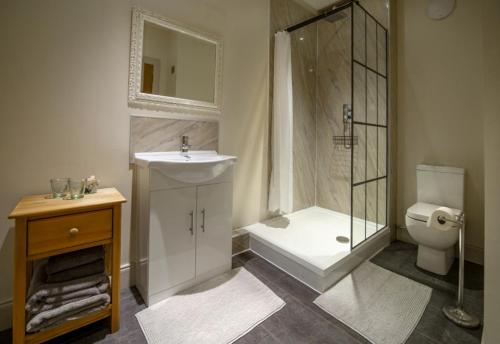 a bathroom with a shower and a sink and a toilet at Kirkaig Lodge in Lochinver