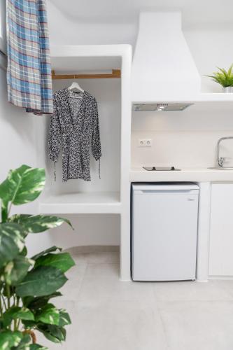 a kitchen with a shirt hanging on a wall at Krina Mare Boutique Hotel in Naxos Chora