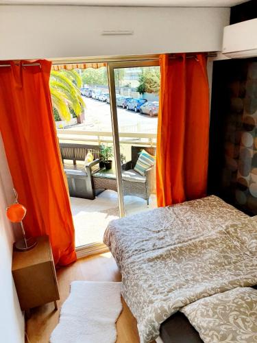 une chambre avec un lit et une grande fenêtre dans l'établissement Bel appartement à 50m de la plage, 2 pièces climatisées, parking privé, à Antibes