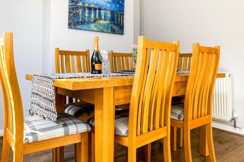 a dining room table with chairs and a bottle of wine at Quaint Victorian Home Close To The Racecourse in York