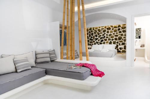a living room with a couch and a mirror at Krina Mare Boutique Hotel in Naxos Chora