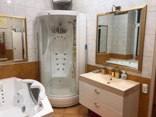 y baño con ducha y lavamanos. en Classical large apartment on Alberta street en Riga