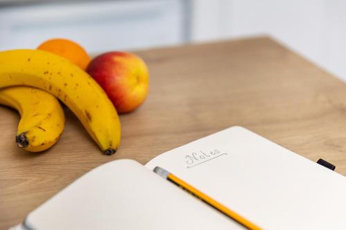 a table topped with bananas and apples and a notebook at Krina Mare Boutique Hotel in Naxos Chora