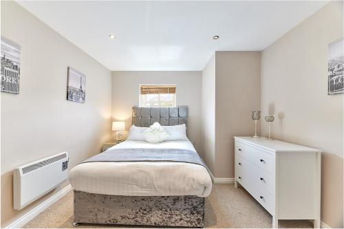 a small bedroom with a bed and a dresser at High Level - Properties Unique in Gateshead