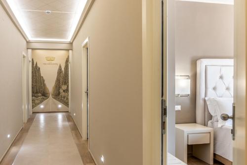un couloir menant à une chambre avec un lit dans l'établissement Hotel Villa Bolgheri, à Marina di Castagneto Carducci
