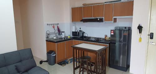 a small kitchen with a refrigerator and a counter top at Swiss Garden Resort Residence, studio, sea & pool view, high level unit in Kuantan