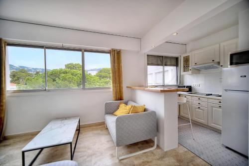 - une cuisine avec un canapé et une table dans une chambre dans l'établissement IMMOGROOM - Cosy - Californie - Proximité de tout, à Cannes