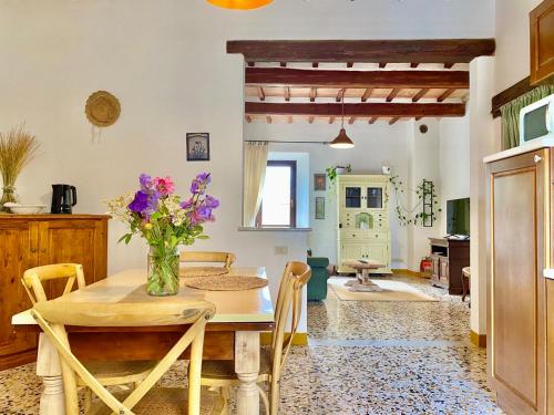 聖奎里科－多爾恰的住宿－Dimora del Poggio a San Quirico d’Orcia，一间设有桌子和花瓶的用餐室