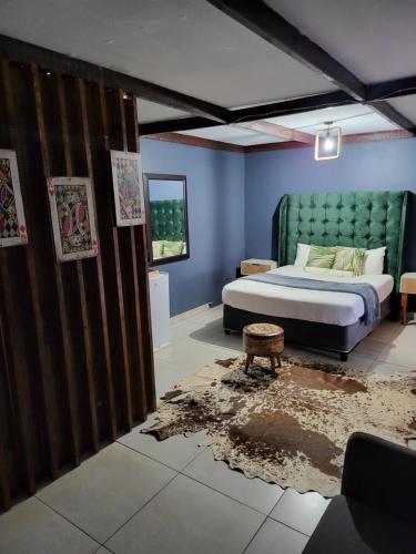 Schlafzimmer mit einem Bett und blauen Wänden in der Unterkunft Shanduka Country Lodge in Thohoyandou