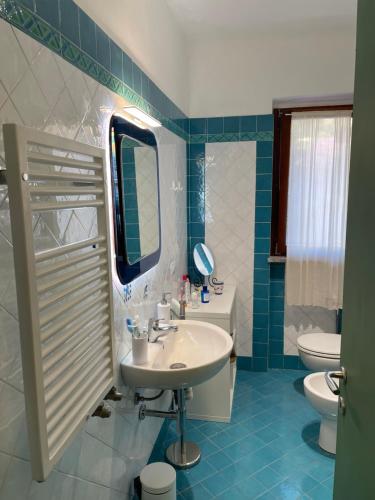 Un baño con lavabo, inodoro y espejo. en Casa di Frilli - a due passi dal mare, en Porto Santo Stefano