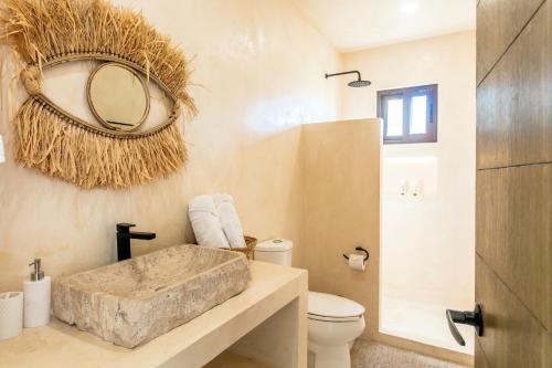ホルボックス島にあるHotel Boutique Casa Muuch Holboxの洗面台、トイレ、鏡のあるバスルーム