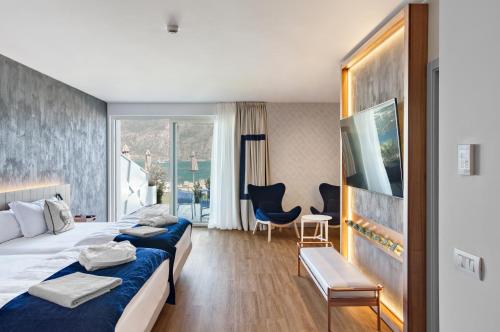 a hotel room with two beds and a desk at Hotel Castello Lake Front in Malcesine