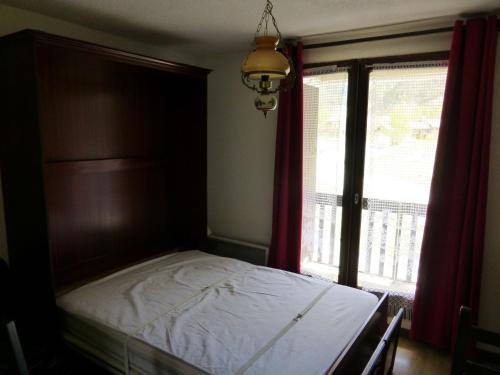 a bedroom with a bed and a window at Jausiers village A 5 in Jausiers