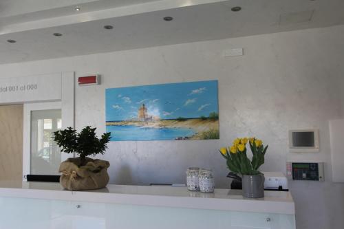 a kitchen counter with a painting on the wall at Hotel Presidente in Porto Cesareo