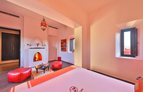 a living room with a fireplace and red furniture at DAR NOUJOUM in Marrakech