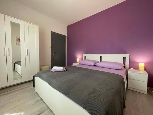 a purple bedroom with a bed with two purple pillows at House Stojakovic in Banjol