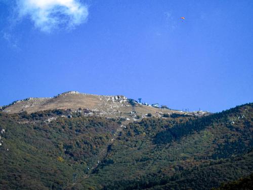 a kite is flying over a mountain at Hotel Alpino in Malcesine