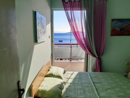 a bedroom with a bed with a view of the ocean at Μαγευτικο ηλιβασιλεμα Μαρμαρι Ευβοιας in Marmari