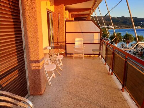 a balcony with a table and chairs on a ship at Μαγευτικο ηλιβασιλεμα Μαρμαρι Ευβοιας in Marmarion