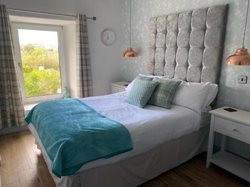 a bedroom with a large bed and a window at No 8 Snowdonia. 3 Bedroom, sleeps 5. Pets accepted in Blaenau-Ffestiniog