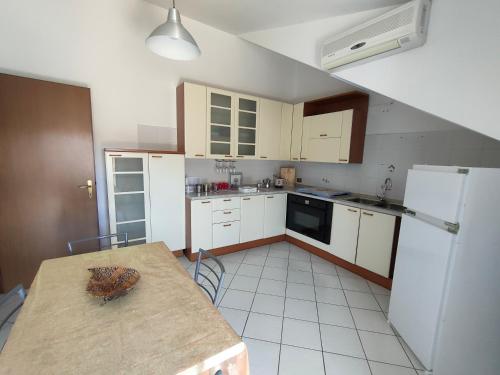 a kitchen with a table and a white refrigerator at Tommaso Domus in Vasanello