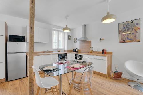 une cuisine avec une table et des chaises dans une pièce dans l'établissement LA PARENTHÈSE - Charmant T2 entièrement rénové, à Toulouse